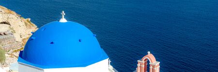 Blue dome churches over the mediterranean sea on Santorini islandの写真素材