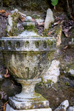 Antique concrete pot, cement vase as decoration in garden.の写真素材