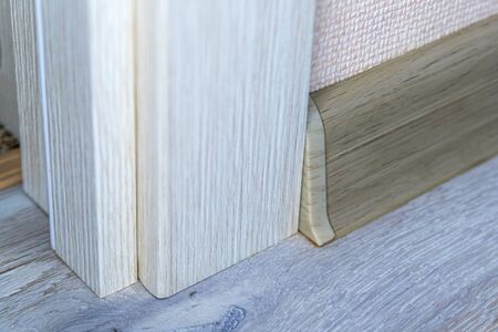 Joining the baseboard to the door frame. End cap on plastic baseboard.の写真素材