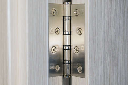 Brand new door hinge. Joinery during repair and installation of doors
