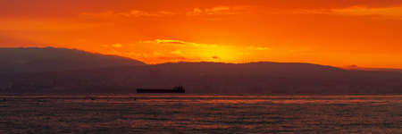 Bright red sunset sky over city and mountains. Fine landscapeの写真素材