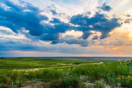 Scenic sunset with clouds in sky in steppe.の写真素材