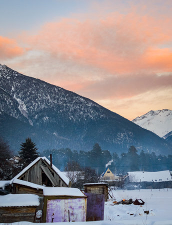 Beautiful winter landscape sunset with snow and village wooden houses.の写真素材