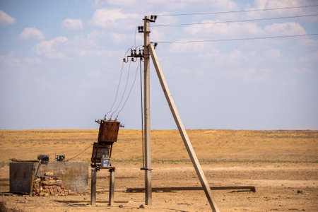 Transformer station near a pillar in steppe. Rural power lines. Electric generators connected to...