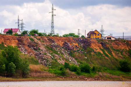 A steep hillside sloping down to the river littered with trash thrown by locals in the village....