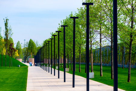 Walking path in a city park with urban lights or lanterns.の写真素材