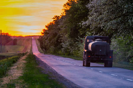 Straight road and colorful sunset. Scenic road landscape.の写真素材