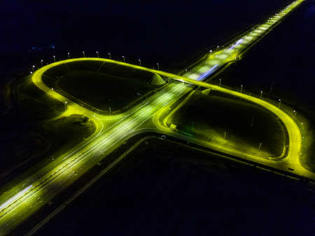 Night roads panoramic background, bird eye view on illuminated highway, modern motorway.の写真素材