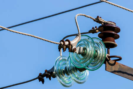 Electric pole against the blue clear sky. Three-phase power line to turn.の写真素材