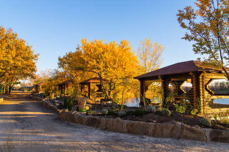 Autumn view of riverside park with wooden houses and benches,の写真素材