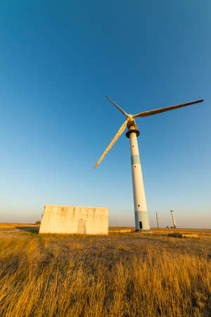 Old abandoned wind turbines in the desert landscape.