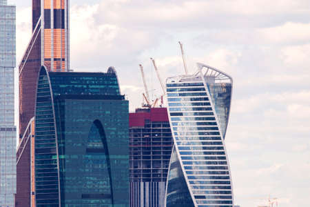 Hoisting cranes and building activity. Construction site of skyscraper.