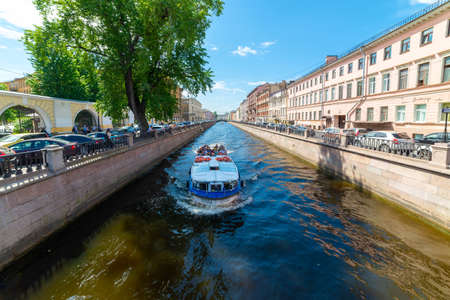 SAINT-PETERSBURG, RUSSIA, JUNE 09, 2021: Excursion ship or boat with tourists sailing along the Griboedov Canal in the center of St. Petersburg.のeditorial素材