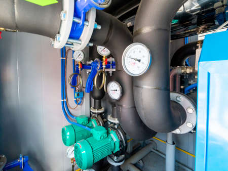 Industrial interior of water pump, valves, pressure gauges, motors inside engine room. Valve and...