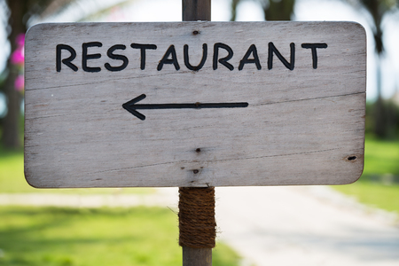 Wooden signboard with Restaurant pointerの写真素材