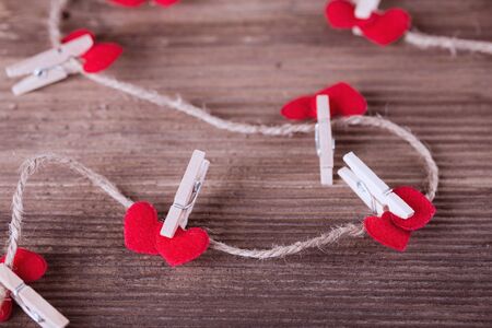 Red textile hearts connected by clothespin. Love concept. の写真素材