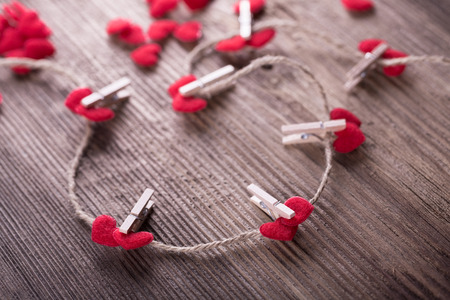 Red textile hearts connected by clothespin. Love conceptの写真素材