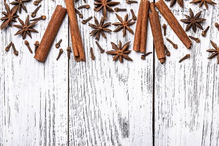 Cinnamon sticks anise stars and cloves whole indian spices on  white wooden background. Top view.の写真素材