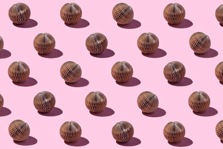 Trendy Christmas and New year pattern made with handmade brown paper balls on bright light pink...