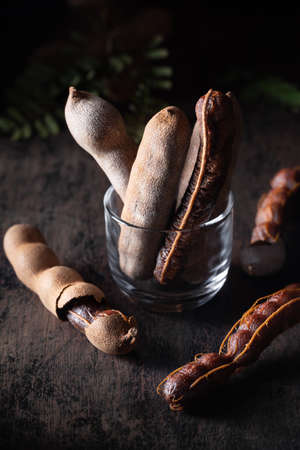 Fresh tamarind fruits on dark rustic background with copyspace. Dark moody. Healthy food, exotic food.の写真素材