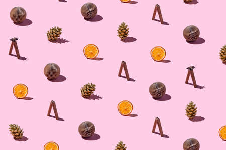 Trendy Christmas pattern made with handmade brown paper balls, spices for mulled vine, pine cones on...