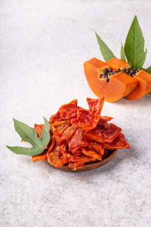 Dried papaya slices on white background vertical. Superfood, vegan, vegetarian food. Healthy snack.