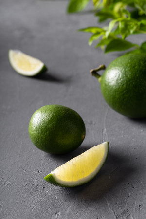 Juicy green limes on gray concrete background. Healthy eating, detox, diet.