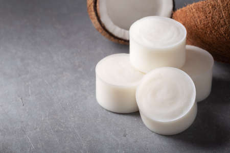 Handmade natural herbal coconut kitchen soap bar white color on gray concrete background. Zero...