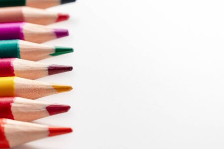 A set, assortment of colorful wooden pencils of different colors laying in row on white background with copy space.の写真素材