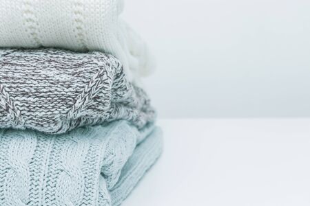 Stack of cozy comfortable homely clean washed knitted pullovers in pastel colors, laundry and...