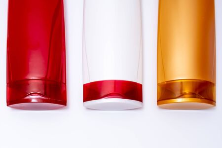 Colorful plastic shampoo and hair conditioner bottles close up on white background.の写真素材