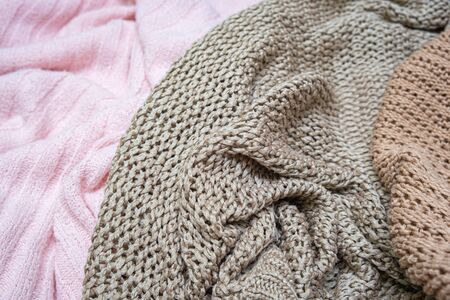 Knitwear background of different colors - pink, beige and brown, washing and laundry of delicate...