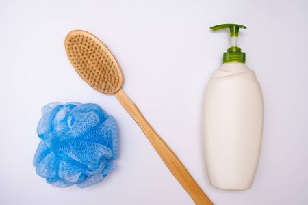 Bath, shower accessories on white background, a bottle of shower gel, body wash with dispenser, wooden brush and a sponge.の写真素材