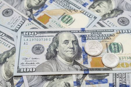 Russian rubles coins lying on american usd dollar background, devaluation of national currency...