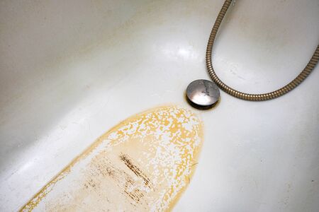 Extremely dirty bath drain mesh, hole and surface covered with limescale or lime scale and rust, cleaning calcified and rusty bathroom equipment.の写真素材