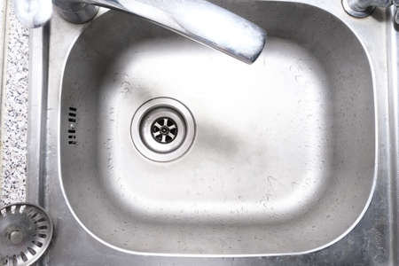 Metal stainless steel kitchen sink with drops of water, top view. Cleaning home and kitcen concept....