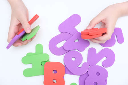 Hands of a child, kid holding colorful numbers during education, learning math