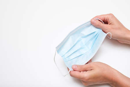 Female hands holding medical protective mask as an effective POV against infection.の写真素材