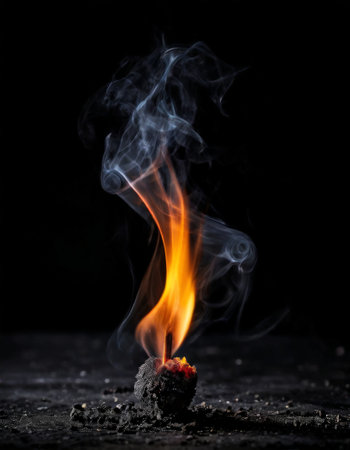 Burning matchstick with vivid flame and swirling smokeの素材
