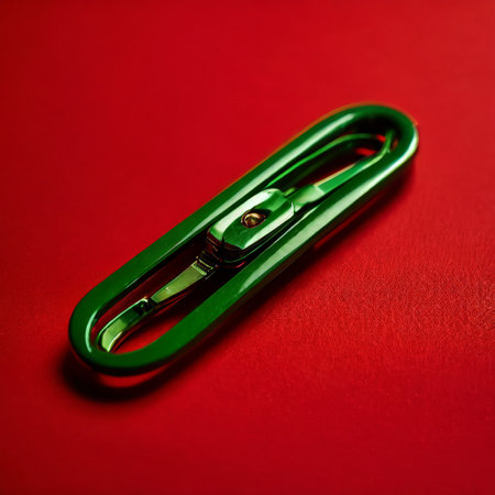 Green metal carabiner clip on a vibrant red backgroundの素材