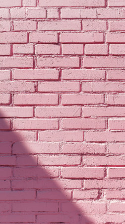 Pink brick wall in sunlight with shadow contrastの素材
