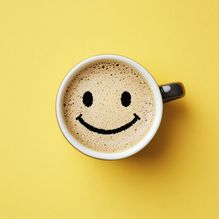 Smiling coffee cup with foam art, black cup on yellow backgroundの素材
