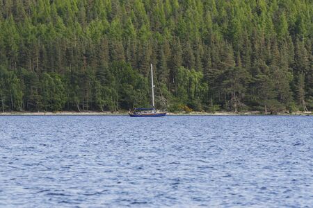A lone boat cruising on Loch Ness Lake in Inverness, Scotland.の写真素材