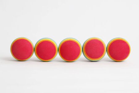 5 colourful foam balls in a line on a white background.の写真素材