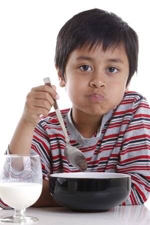 A young boy eating cereal and milk for breakfastの写真素材