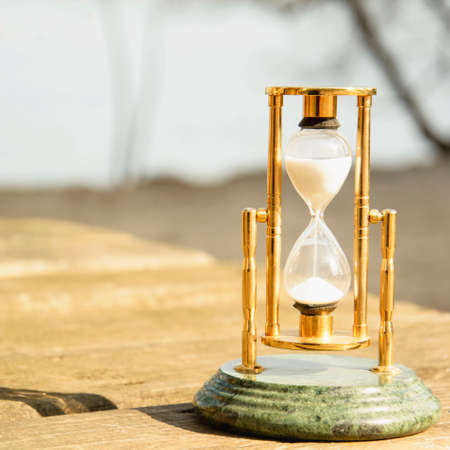 Glass beautiful hourglass on the background of beautiful nature