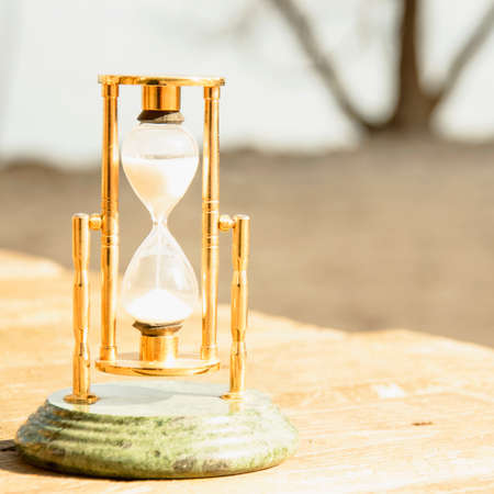 Glass beautiful hourglass on the background of beautiful natureの写真素材