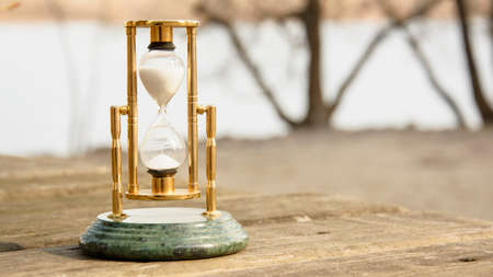 Glass beautiful hourglass on the background of beautiful nature