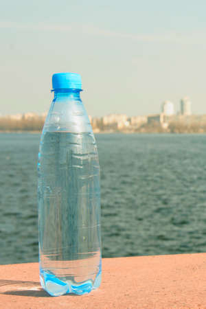 Plastic bottle with clean water on the background of beautiful natureの写真素材