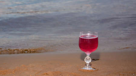 Red dry wine in glass glasses on the bank of a large riverの写真素材